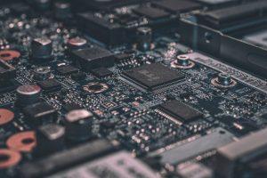 Placa de circuito eletrônico vista de perto, com chips e componentes