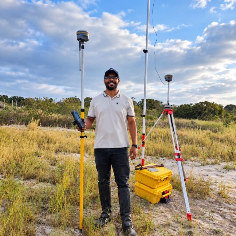 Engenheiro da Ventura Engenharia em campo, com receptor GNSS em tripé e caixas amarelas
