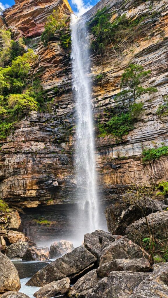 Cachoeira do Ventura caindo em fio único por uma parede de pedra, com blocos de rocha no pé da queda