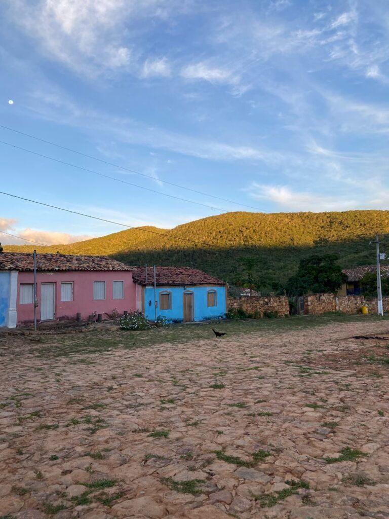 Casas térreas coloridas da Vila do Ventura diante da serra, com a rua de terra em primeiro plano