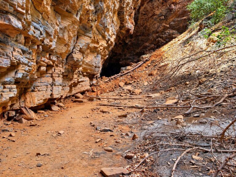 Trilha de terra no cânion até uma entrada da Gruta dos Brejões, ao pé do paredão de rocha em camadas