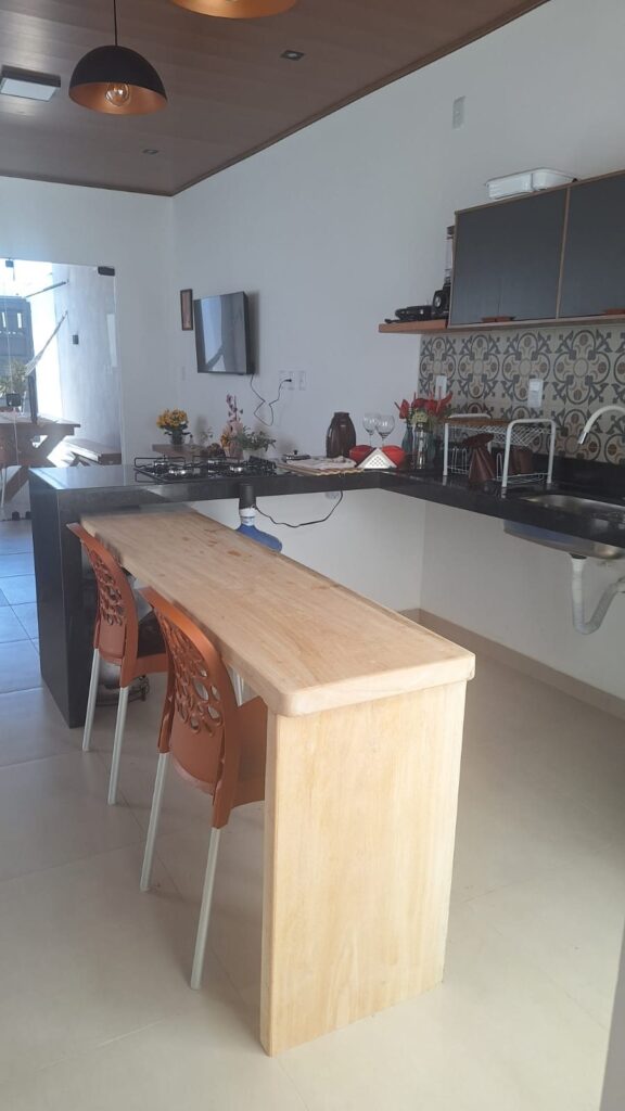 Cozinha americana da Casa de Mamãe com bancada de madeira