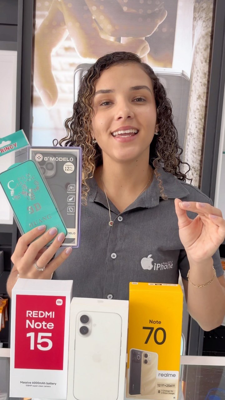 Vendedora de loja de celulares exibindo caixas de smartphones e acessórios