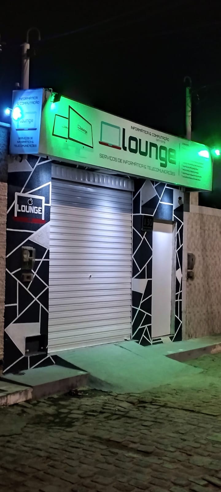 Letreiro da Lounge Serviços de Informática e Telecomunicações visto em ângulo, em Morro do Chapéu